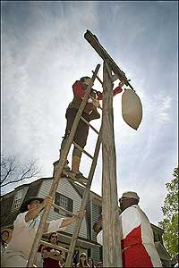 Greg James, left, Cash Arehart, and Art Johnson prepare a liberty pole—with its bag of feathers and bucket of tar—for reluctant loyalists.