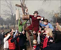 Holding a barrel of tar, Bill Rose churns up the crowd.