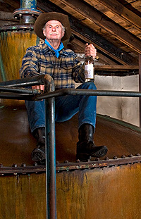 In Culpeper County, Virginia, Chuck Miller sits on his still. In 1986, he squashed grape growing in favor of corn mashing.