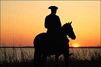 Richard Nicoll, director of coach and livestock, enjoys a James River sunset
with horse Pete.