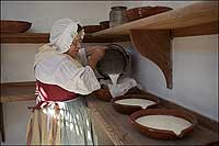 Shirley strains milk into a milk pan