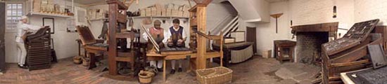 Working in the print shop are, left to right, Journeyman Printer Peter Stinely at the typebox, Master Printer Willie Parker with the paten, and Interpreter Chadwick Jones with the ink balls. - Barbara Temple