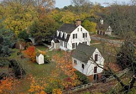 In the backyard of Williamsburg’s restored Tayloe House, above, stand two wooden outhouses—one partially obscured by trees—as dimly seen in the nineteenth-century photo below.