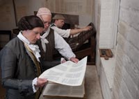 Stith checks sheets printed by William Parker of his 1747 History of the First Discovery and Settlement of Virginia. The book was the first of its kind published primarily for an American audience. Journeyman printer Peter Stinely as Parker, with David Wilson.