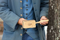 A mallet positions the spile into the maple tree.