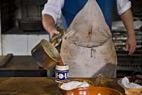 Jim Gay pours heated chocolate into his mug.